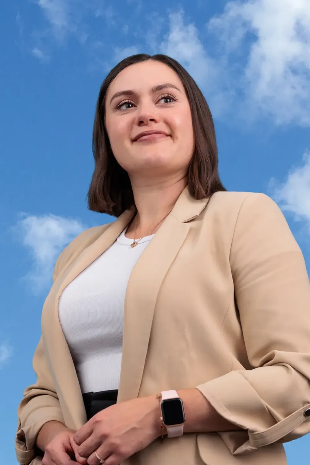 Woman captured from a low angle under a blue sky looking into the distance