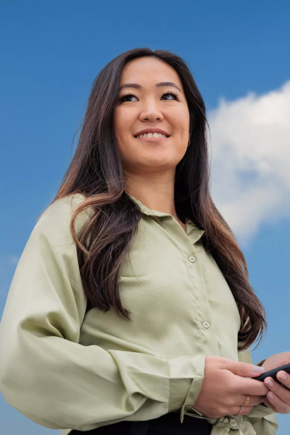 Woman portrayed outdoors with natural light and open sky behind