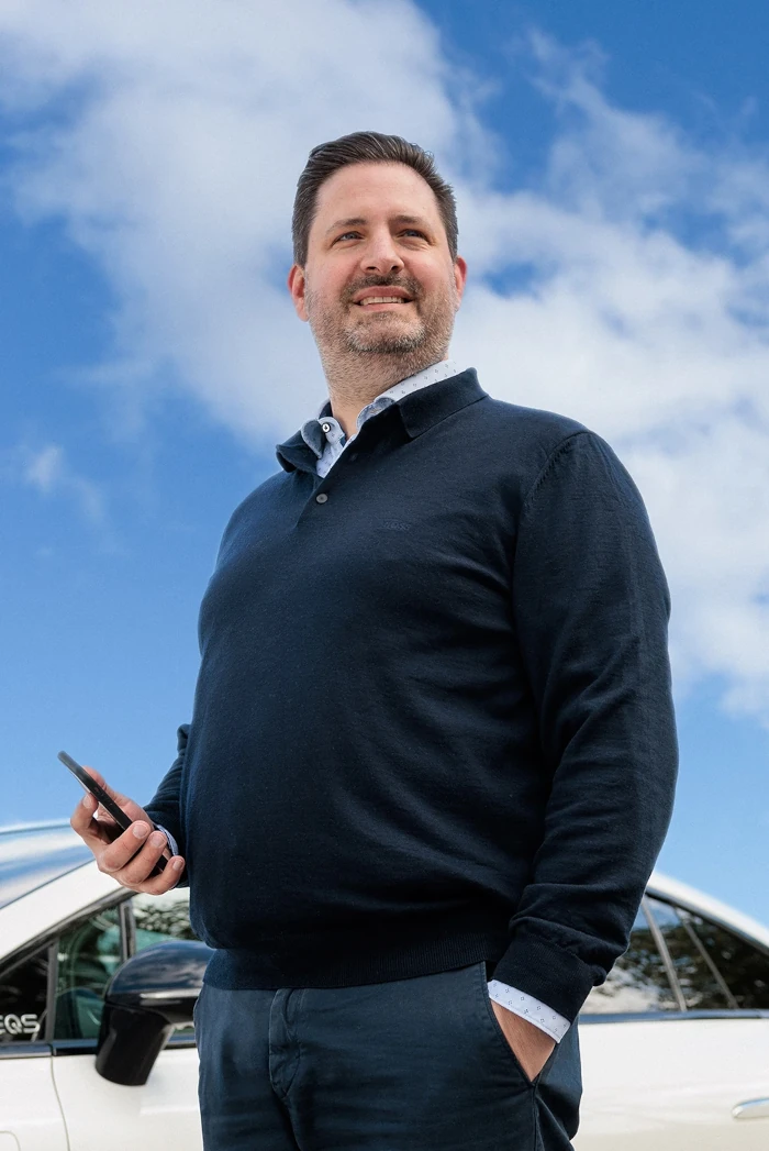Man standing outdoors in front of blue sky with clouds looking into the distance